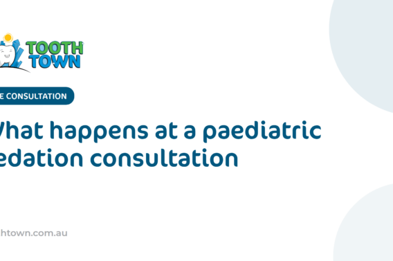 A paediatric dentist kneeling to chat with a young child and their parent in a consultation room